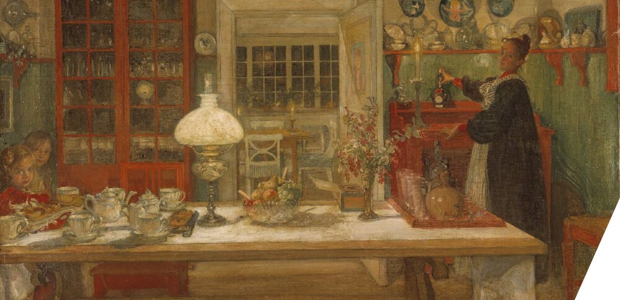 A family seated around a table full of crockery, looking at the viewer